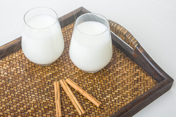 Two glass of vegatarian rice milk and rice grains served on a tray.  An invigorating healthy breakfast. Non dairy alternative milk. Concept of proper nutrition and healthy eating. Organic food.