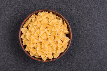 Farfalle or Bow Tie Pasta in bowl on gray background. Italian pasta