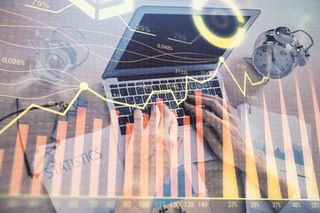 Multi exposure of forex graph with man working on computer on background. Concept of market analysis.