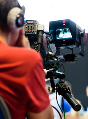 Professional cameraman with headphones with HD camcorder in live television