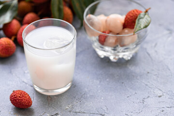 Sweet lychee juice on the gray background Closeup of fresh lychee juice with fruits.