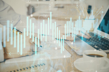 Multi exposure of stock market graph with man working on laptop on background. Concept of financial analysis.
