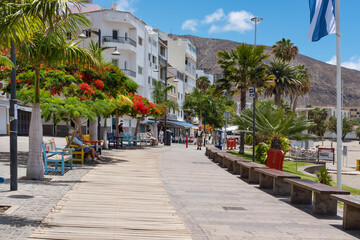 Few residents resting or walking on the usually very busy promenade in front of Playa Los Cristianos on Av. Juan Alfonso Batista in Los Cristianos, Arona, Tenerife, Canary Islands, Spain - obrazy, fototapety, plakaty