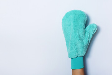 Hand in glove holding microfiber cleaning cloth, cleaning mitten on white background. Copy space. Cleaning service concept. Spring general or regular clean up. Commercial cleaning company concept.