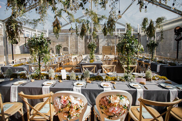 wedding table decorated by plates, knives and forks, candle, moss and greenery