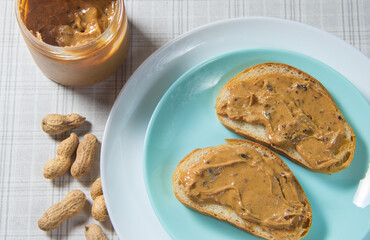 Two peanut butter sandwiches in close-up. The peanut butter sandwich is on the plate