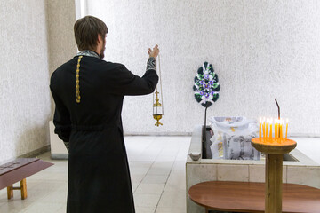 Funeral service of the deceased by an Orthodox priest in a crematorium