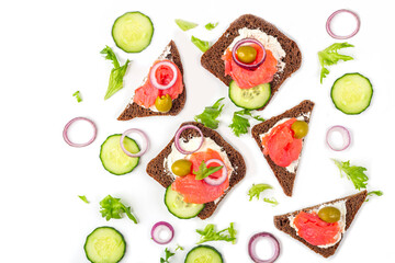 Appetizer, open sandwich with salmon, onion and cucumber on white background. Traditional Italian or Scandinavian cuisine. Concept of proper nutrition and healthy eating. Flat lay, copy space for text