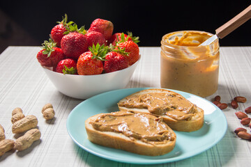 Breakfast with coffee and sandwiches with peanut paste and strawberries