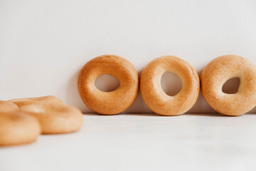 Drying or mini round bagels on a white wooden background. Copy, empty space for text