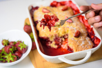 homemade strawberry cobbler made from ripe fresh strawberries. cut strawberry pie on a blue plate on a light background