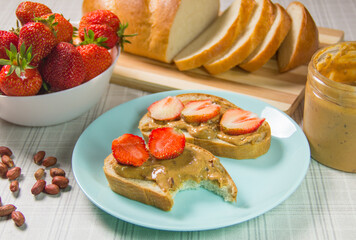 Peanut butter and strawberry sandwiches. Breakfast the view from the top. Plate of sandwiches with peanut butter, jam and fresh fruits from top view