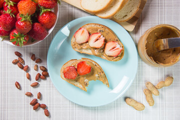 Peanut butter and strawberry sandwiches. Breakfast the view from the top. Plate of sandwiches with peanut butter, jam and fresh fruits from top view