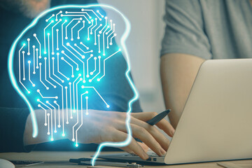 Businessman with computer background with brain theme hologram. Concept of brainstorm. Multi...