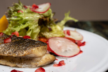 Baked sea fish with vegetables radish, lettuce, lemon and tomatoes. Good proper nutrition, weight loss, maintaining the health of the body. Keto diet, gluten-free diet.