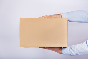 Cardboard box in male hands. Parcel delivery home. Gift