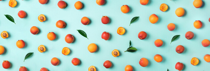 Apricot pattern on blue background. Top view, flat lay. Fresh summer fruit concept. Creative...