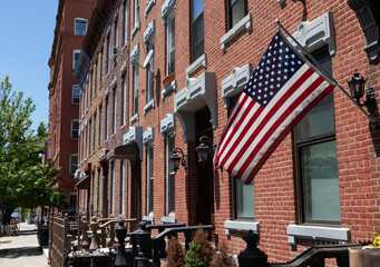 American Flag Outside a Row of Old Red Brick Homes in Greenpoint Brooklyn New York