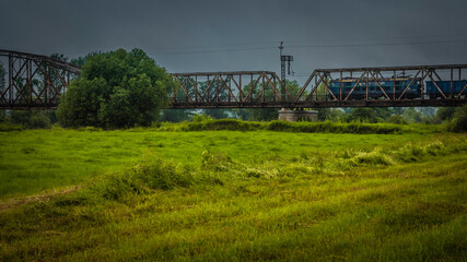 A blue train on a bridge over the  River Odra.