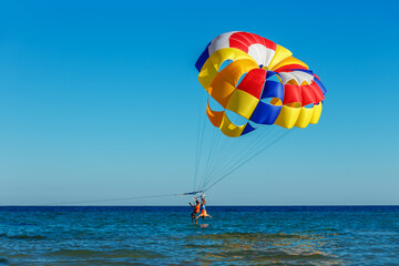Fototapeta na wymiar Tourists fly over the sea on a parachute