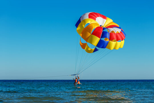 Tourists fly over the sea on a parachute
