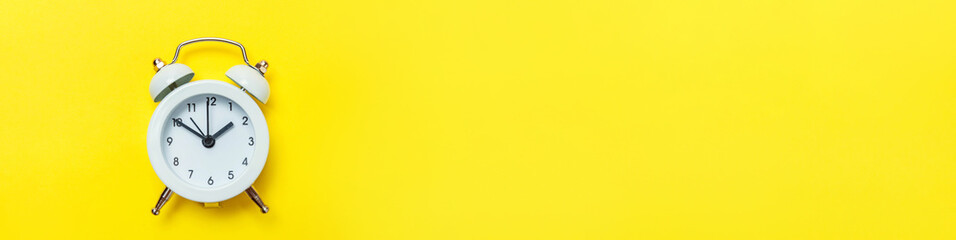 Simply minimal design ringing twin bell classic alarm clock Isolated on yellow background. Rest...