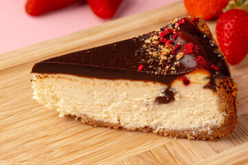 Piece of cheesecake with chocolate top and berries