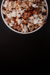 half picture of caramel popcorn in a paper bowl 