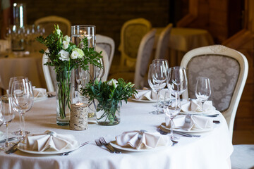 
A delightful floral arrangement in green colors in a rustic style on a banquet table to create a romantic atmosphere.