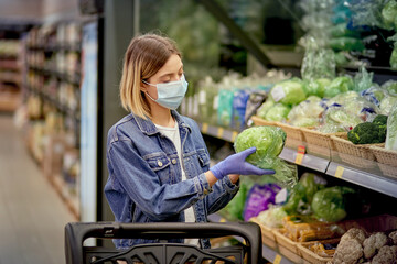 A blonde girl is standing near a shelf in fresh vegetables.