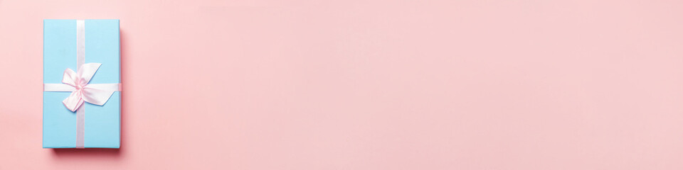 Christmas New Year birthday valentine celebration present romantic concept. Simply minimal design blue gift box isolated on pink pastel colorful background. Flat lay top view copy space, banner