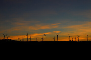 Wind turbines generating electricity with twilight sky - energy conservation concept