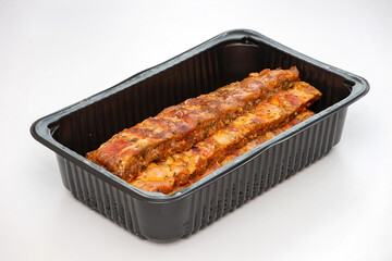 Pickled ribs in a plastic container.
