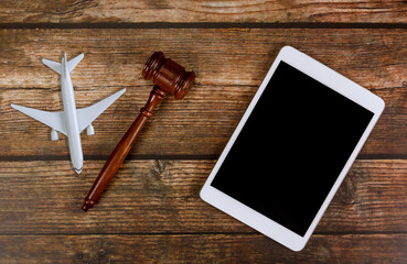 Judge traveling concept planning airplane on wooden judges gavel with digital tablet in airplane model plane