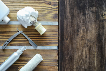 Shaving accessories on a wooden texture background. Tools. Disposable shaving machine, brush, foam and hazard razor.