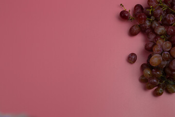 Red grapes on the pink background