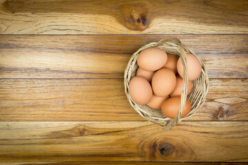 Top view, eggs in a basket placed on a wooden table.