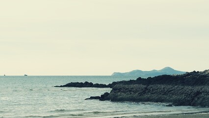 View of the beach with rocks leading into the sea