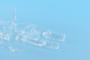several ampoules with colorless medicine on a blue background