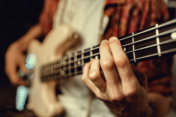 Fototapeta na wymiar Close up of male hand playing electric guitar in the dark
