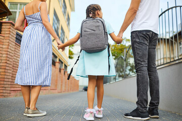 Family and schoolgirl with a backpack way to school