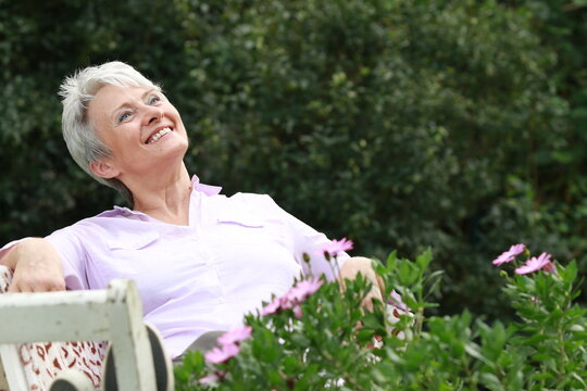 Smiling attractive eldery woman in her garden