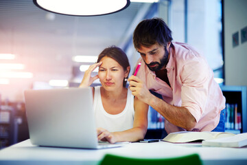 Male executive showing to employer things on laptop while they working in modern office, two students working together at a computer in a university library, business people discussing ideas, flare