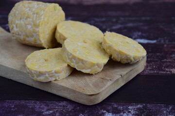 Slices of tempeh (fermented soybean) on the wooden board