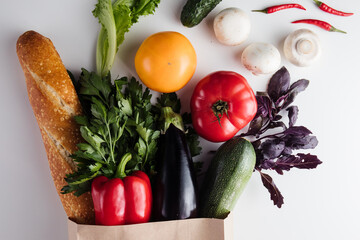 Healthy vegetarian vegan clean food in paper bag vegetables and fruits on stone background. Shopping supermarket and organic vegan diet concept