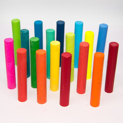 Crayons of different colours,  haphazardly displayed on a white background standing upright with use of selective focus.