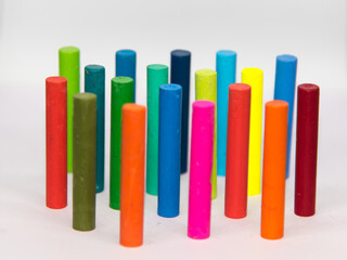 Crayons of different colours,  haphazardly displayed on a white background standing upright with use of selective focus and background blurred.
