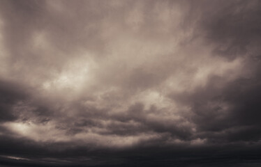 Fototapeta premium Gray storm clouds fill the dark horizon as grey clouds fills the fear inducing sky above.