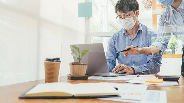 Asian People Successful Teamwork Business Wearing Medical Mask and Working. Work from Private Office Social Distancing among Coronavirus Outbreak Situation. New Normal After COVID19.