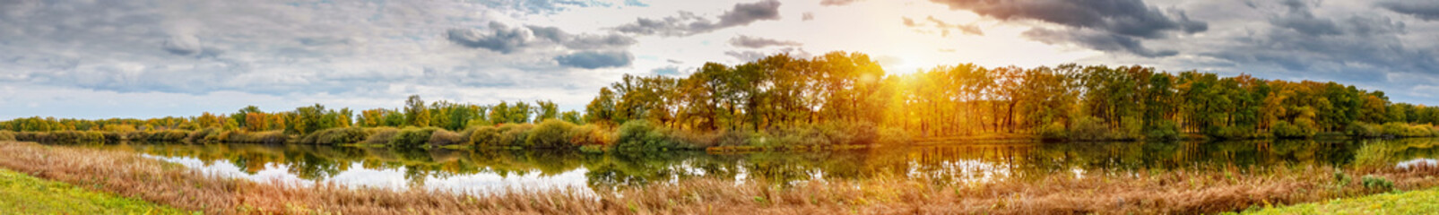 Panorama beautiful sunset over autumn forest and lake